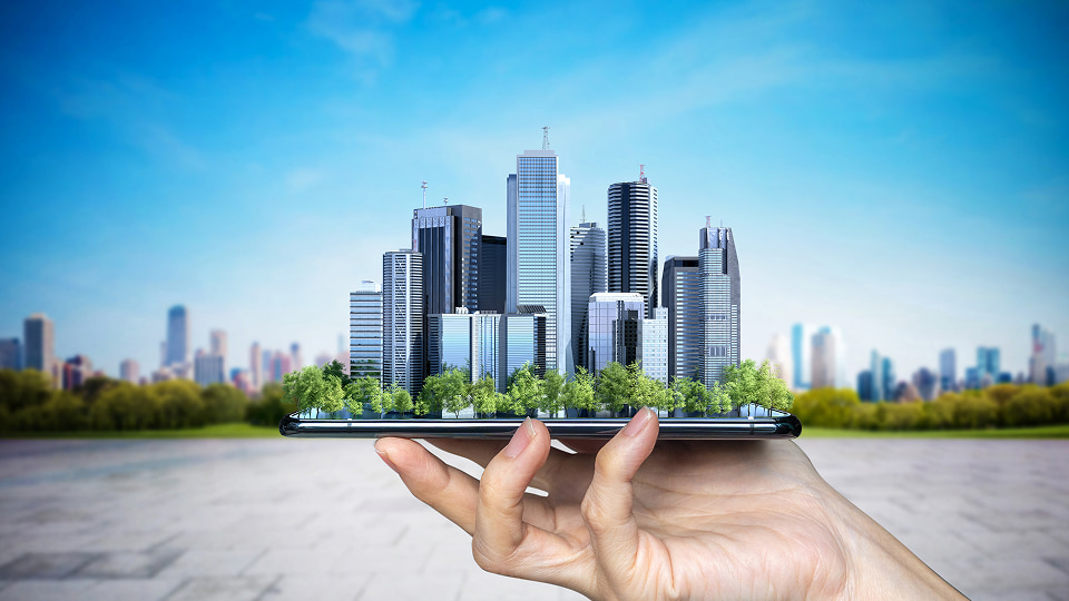 Hand holding smartphone with 3D city skyline emerging, symbolizing smart city and digital innovation.